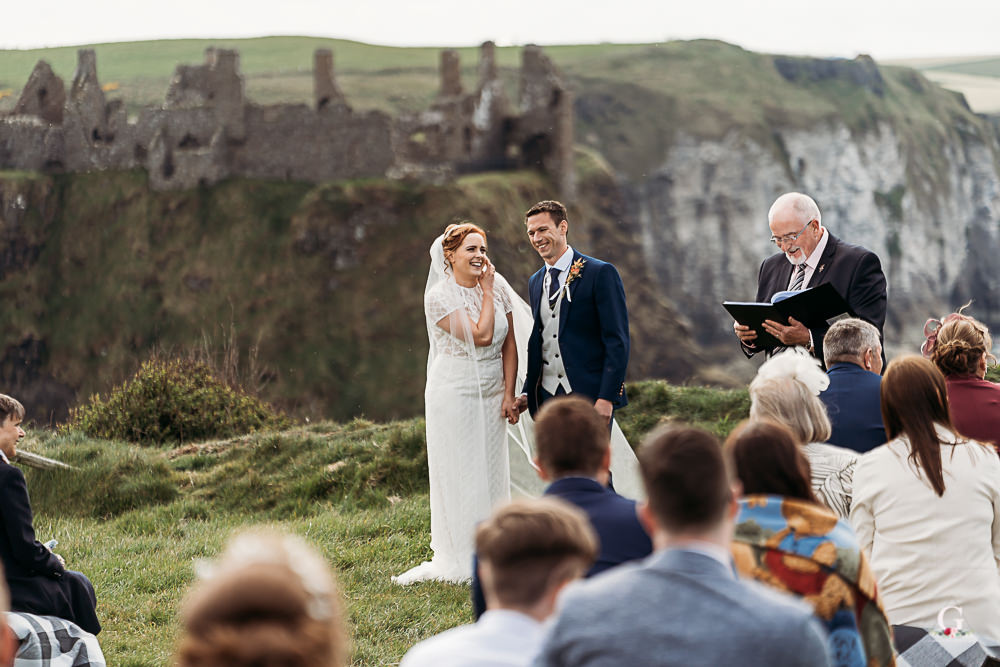 John Foley leading an outdoor ceremony in front of guests at a coastal location
